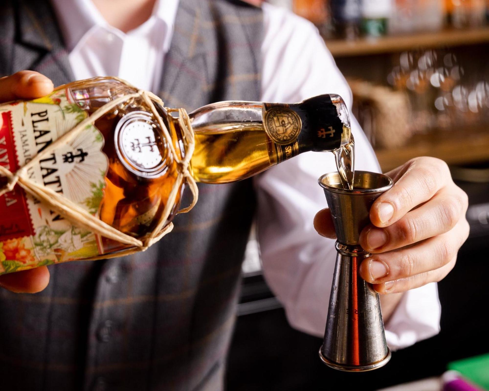 Hotel Kimpton - Fitzroy London By Ihg Esterno foto A bartender using a jigger to measure a shot of rum